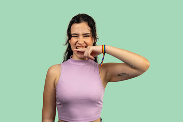 Young woman biting finger and winking expressing playful mischief