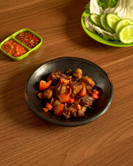 Tender Beef Ribs Stir-Fried in Spicy Sauce, Served with Sambal and Fresh Sundanese-Style Lalapan Vegetables.