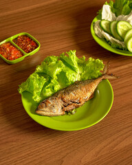 Savory and Salted Peda Fish Served with Fresh Vegetables and Spicy Sambal for a Bold and Traditional Indonesian Meal.