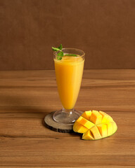 A Glass of Refreshing, Sweet, and Tropical Mango Juice Served Cold with Fresh Mango Slice for a Flavorful Presentation.