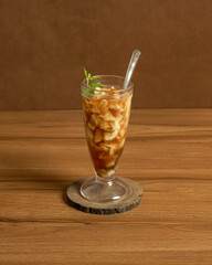 A Refreshing Tropical Drink of Fresh Coconut Water and Tender Flesh Sweetened with Palm Sugar, Served Cold in a Glass.