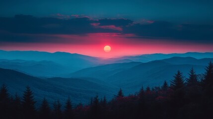 Mountain range at sunset. Trees in foreground, layers of distant hills, and sun over