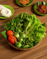 Fresh Lalapan Served with Spicy Sambal and Crispy Crackers A Traditional Indonesian Side Dish Featuring Raw Vegetables and Flavorful Chili Condiment