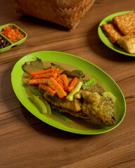 Nila Pesmol with Tofu, Tempeh, and Sambal Traditional Indonesian Fried Fish in Yellow Spiced Sauce, Served with Spicy Chili Condiment.