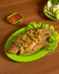 Traditional Indonesian Spicy Gourami Fish Dish Served with Fresh Greens and Bold Chili Sambal for a Flavorful Meal.
