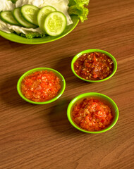 Three Kinds Of Indonesian Chili Sambals With Cucumber Slices, Cabbage, And Lettuce As Classic Sundanese Side Dish.