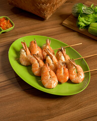 Grilled Shrimp Satay Served with Spicy Sambal and Fresh Vegetables, A Flavorful Indonesian Seafood Dish with Bold and Traditional Taste.