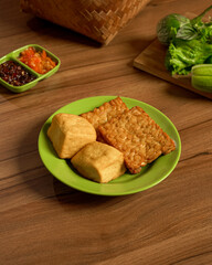 Golden Fried Tofu And Tempeh With Fresh Raw Vegetables And Spicy Sambal On The Side, An Indonesian Dish Full Of Crunch And Flavor.