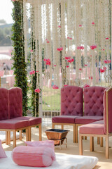Elegant wedding seating area featuring tufted chairs, floral backdrop, and traditional elements. A perfect blend of modern and traditional design.