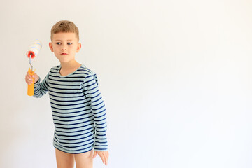 A young boy renovating a room, sanding the walls with sandpaper and painting them white with a...