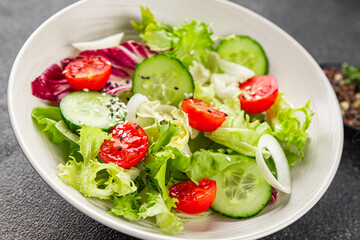 Salad vegetable tomato, cucumber, lettuce, green leaf lettuce, onion appetizer vegetable dish fresh gourmet food background rustic food top view copy space keto and paleo diet vegetarian vegan food