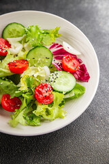 Salad vegetable tomato, cucumber, lettuce, green leaf lettuce, onion appetizer vegetable dish fresh gourmet food background rustic food top view copy space keto and paleo diet vegetarian vegan food
