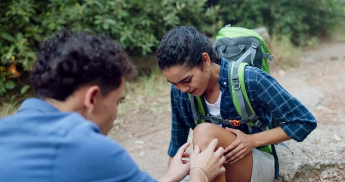Couple, nature or injury in knee with hiking, joint dislocation or woman with stress in pain. Man, fitness or help girlfriend on trekking trail with leg emergency, accident or torn ligament for touch