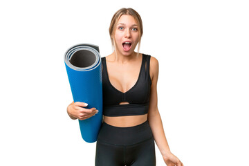 Blonde sport woman going to yoga classes while holding a mat over isolated chroma key background...