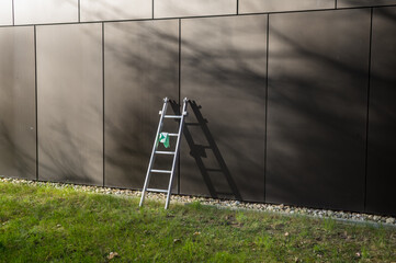 Metal ladder leaning against modern building facade