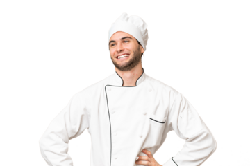 Young handsome chef man over isolated background posing with arms at hip and smiling