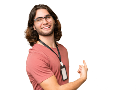 Young handsome man with ID card over isolated background pointing back