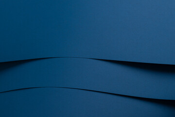 Matte designer paper texture with layered, curved arcs and smooth surface. Elegant, clean composition in deep navy, ocean blue, and royal blue tones. Stylish, moody, and cool monochrome backdrop with.