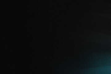 A dark and blurry image with a hint of blue and green tones visible in the lower right corner area