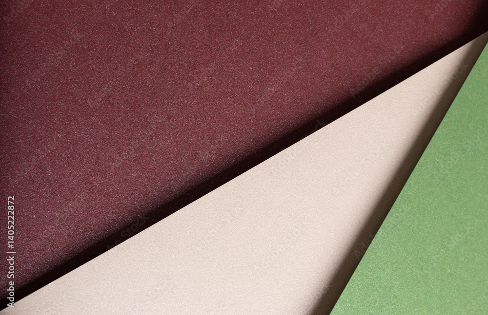 Poster paper background with matte texture. layered diagonal sheets in burgundy, maroon, champagne, soft be