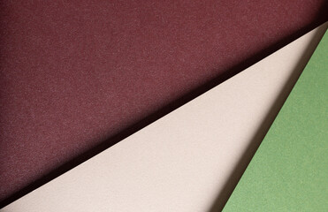 Paper background with matte texture. Layered diagonal sheets in burgundy, maroon, champagne, soft...