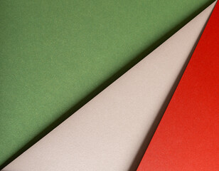 Paper background with matte texture. Layered diagonal sheets in crimson red, pastel green, mint...