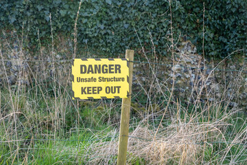 Keep out sign in a fenced of ruin in the countryside