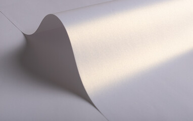 Paper background with satin pearlescent texture. Glossy folded curves, smooth surface in pale lilac...