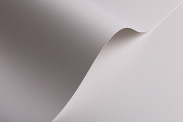 Pearl satin paper background with a glossy, smooth texture and graceful curved folds. Pale grey and...