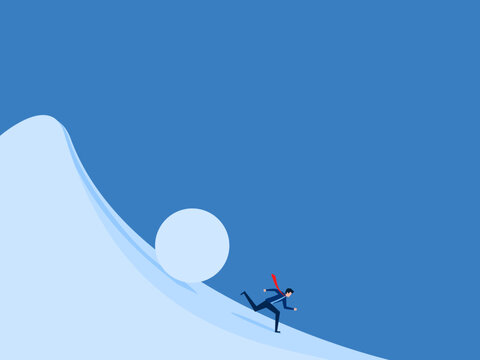 man runs away from a large snowball rolling down a hill.