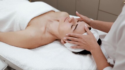 Cosmetologist, beautician doctor doing facial massage, cosmetic procedure for female face rejuvenation, pinch and roll anti-aging technique, professional treatment in a beauty clinic salon for woman