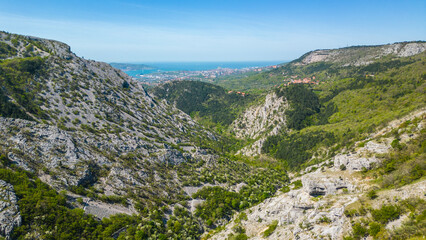 Naklejka premium Aerial view of the Giordano Cottur cycle and pedestrian path near Trieste, Italy, winding through the stunning Val Rosandra Nature Reserve. This scenic trail follows a dramatic canyon, panorama