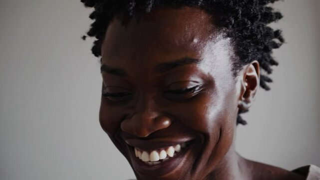 Smiling dark-skinned woman looking into camera, positive and diverse portrait