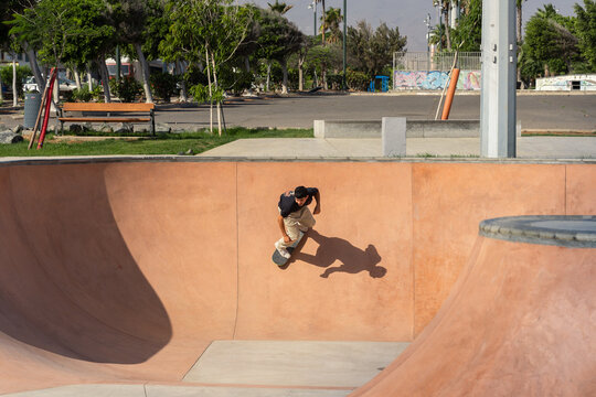 young man in black t-shirt skating at a skate park in a sunny day. Arinaga. Gran Canaria. Canary Islands