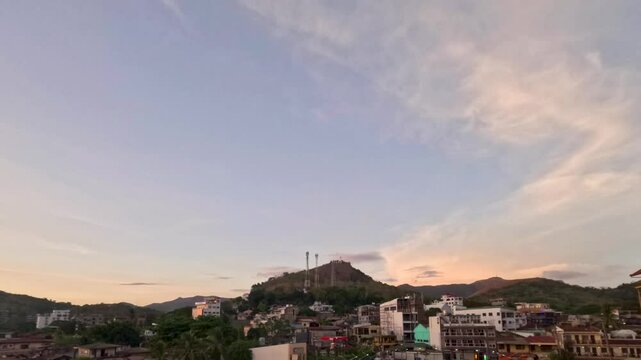 Coron town at dusk below Mt Tapyas with pastel sunset sky hillside buildings town lights and tropical evening skyline in Palawan