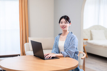 自宅で笑顔でリモート会議に参加する若い女性