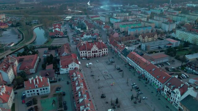 Top-down drone view of Pisz town square and historic Ratusz in Masuria Poland at twilight