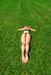 Young woman lying on the grass and tans on a beautiful day of summer