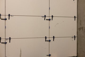 Wall leveling system. Instalation of ceramic tile in a bathroom.