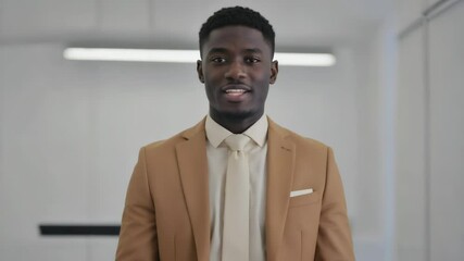 A formal gentleman wearing a tan suit and white tie, suitable for business or social occasions.
