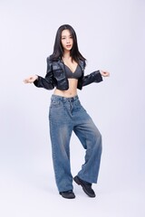 Stylish Asian Thai woman striking playful pose in leather jacket and jeans
