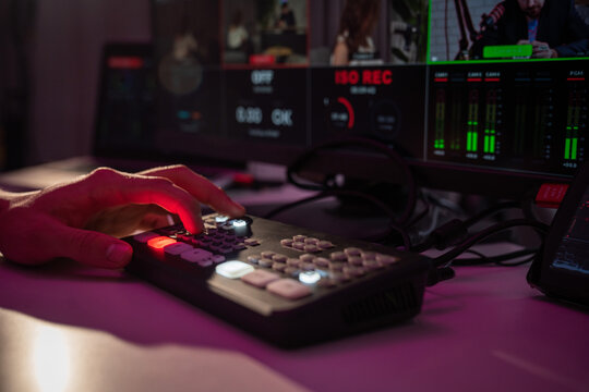 Hand Operating Video Production Control Panel in Dimly Lit Studio