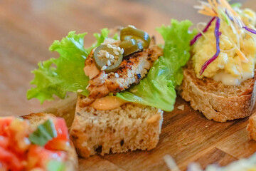 Close up of bruschetta with lettuce, grilled chicken and jalapeno