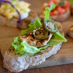 Close up of bruschetta with lettuce, grilled chicken and jalapeno