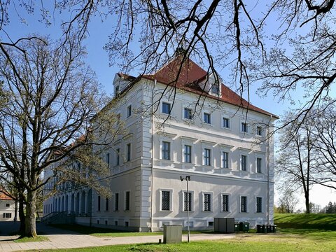 Birzai castle in Lithuania A large, white, two-story building with a red-tiled roof and multiple dormer windows. 