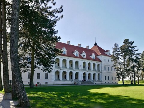Birzai castle in Lithuania A large, white, two-story building with a red-tiled roof and multiple dormer windows. 