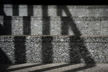 Shadow of handrails on marble staircase steps