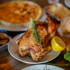 Whole roasted chicken with rosemary and lemon on the table