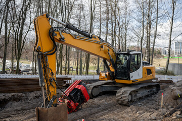 Heavy yellow excavator operating at an urban construction site