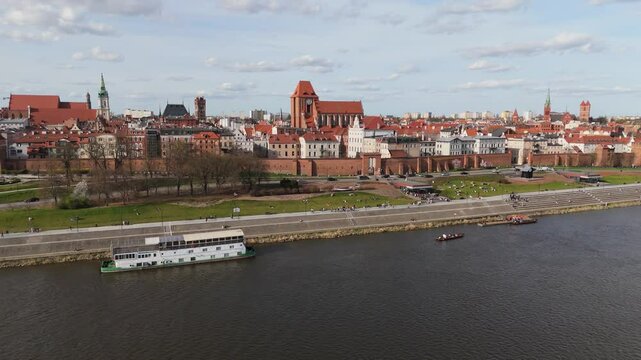 Aerial view on sunny day on Vistula river embankment, historical tourist center of medieval city Torun, old town, churches, cathedrals, Poland, Europe